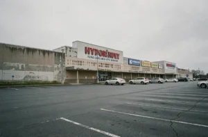Facade d'un hypermarché Cora avec parking quasi vide, symbole de la chute commerciale d'une enseigne historique
